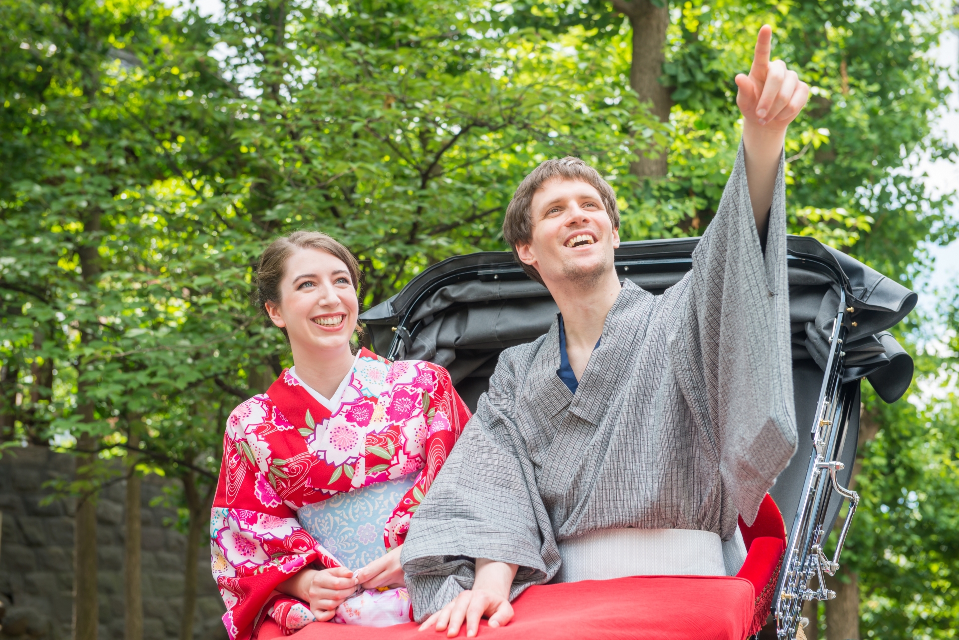 着物を着たカップルが人力車で楽しそうにしている様子
